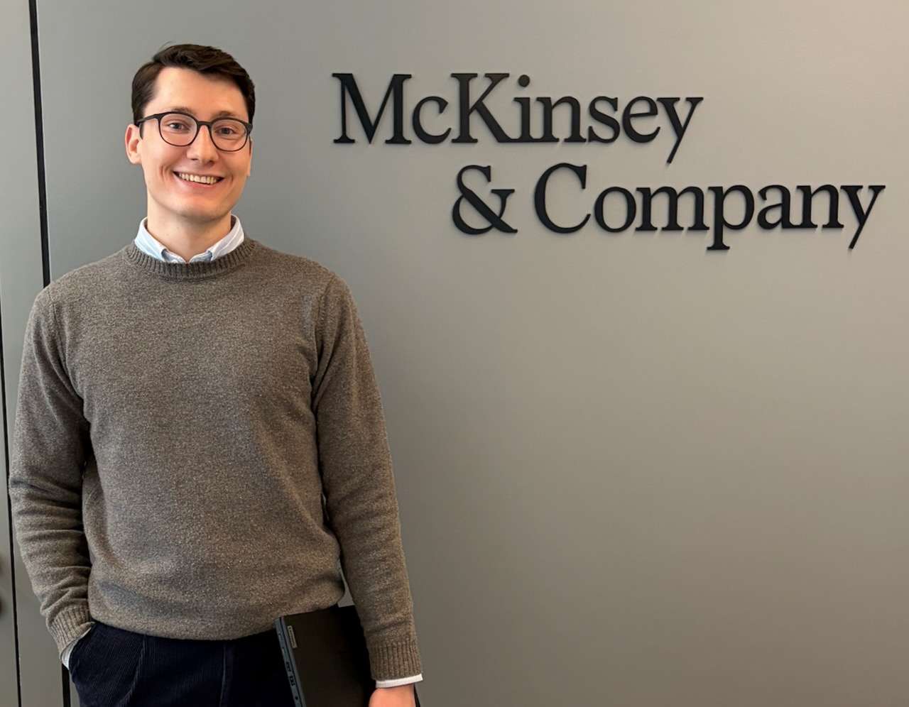 Maximilian Schmidt vor dem McKinsey & Company Logo